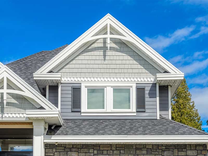 Gray shake and lap siding with white trim on a residential gable